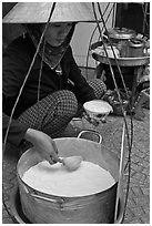 Woman serving a bowl of soft tofu. Ho Chi Minh City, Vietnam (black and white)