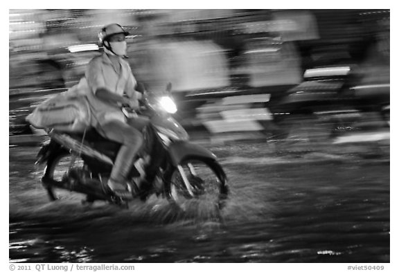Motorcycle rider photographed with panning motion at night. Ho Chi Minh City, Vietnam (black and white)