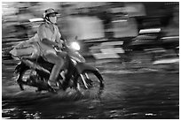 Motorcycle rider photographed with panning motion at night. Ho Chi Minh City, Vietnam (black and white)