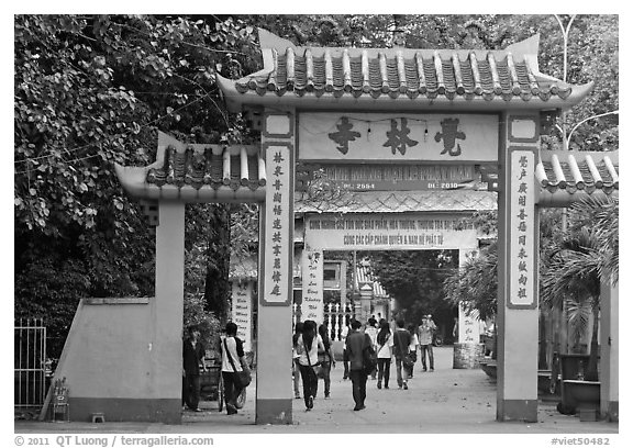 People walking through gates, Giac Lam Pagoda, Tan Binh District. Ho Chi Minh City, Vietnam (black and white)