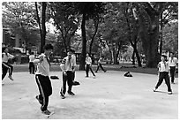 Schoolboys playing a feet badminton game, Cong Vien Van Hoa Park. Ho Chi Minh City, Vietnam (black and white)