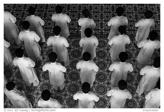 Worshippers dressed in white stand in rows in Cao Dai temple. Tay Ninh, Vietnam