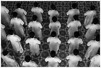 Worshippers dressed in white stand in rows in Cao Dai temple. Tay Ninh, Vietnam (black and white)