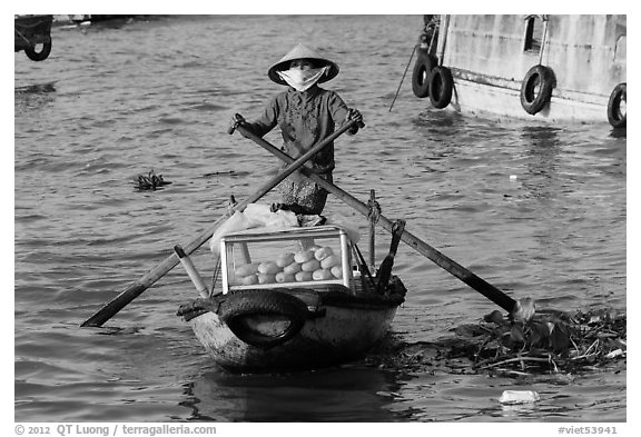 Woman paddling boat with breads, Cai Rang floating market. Can Tho, Vietnam (black and white)