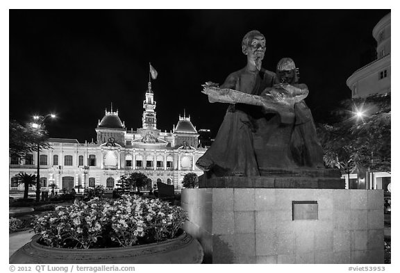 Ho Chi Minh as teacher bronze by Diep Minh Chau and City Hall by night. Ho Chi Minh City, Vietnam