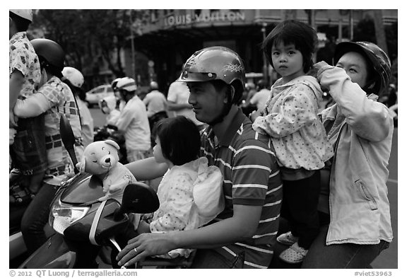 Family on motorbike watching musical performance. Ho Chi Minh City, Vietnam (black and white)