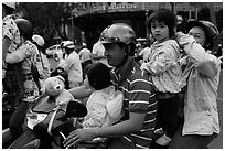Family on motorbike watching musical performance. Ho Chi Minh City, Vietnam (black and white)