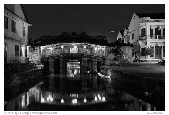 Covered Japanese Bridge reflected in canal by night. Hoi An, Vietnam (black and white)