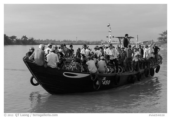 People crossing river on small ferry. Hoi An, Vietnam
