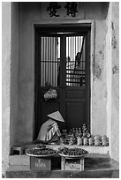 Ceramics vendor, blue temple door. Hoi An, Vietnam (black and white)