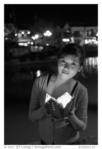 Woman holding candle box at night. Hoi An, Vietnam (black and white)