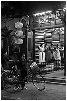 Women with bicycles in front of taylor shop. Hoi An, Vietnam ( black and white)