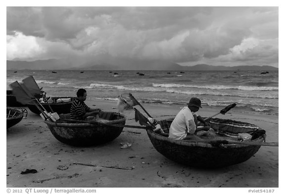 Fishermen mending nets in coracle boats. Da Nang, Vietnam