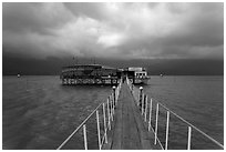 Pier leading to restaurant on stilts. Vietnam ( black and white)