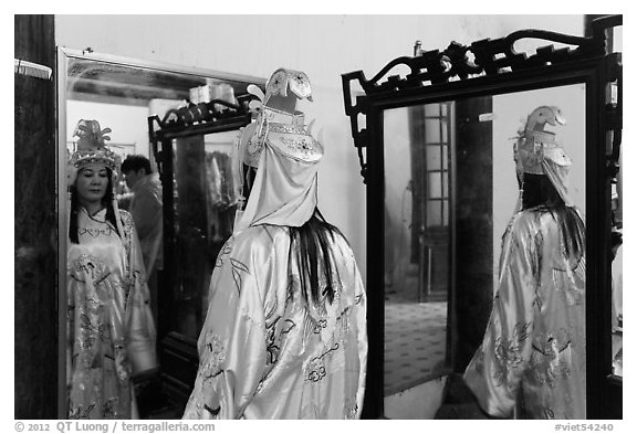 Woman in imperial dress checking herself in mirror, citadel. Hue, Vietnam (black and white)