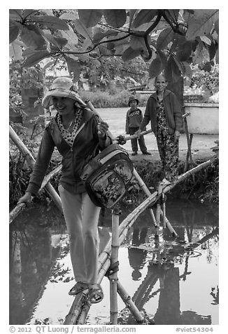 Women crossing monkey bridge, Thanh Toan. Hue, Vietnam (black and white)