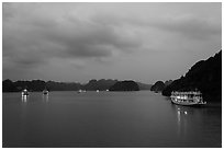View of bay with lights of anchored tour boats at dawn. Halong Bay, Vietnam ( black and white)