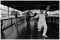 Morning Tai Chi session on tour boat deck. Halong Bay, Vietnam (black and white)