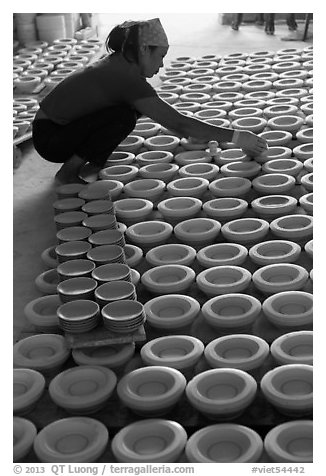 Woman laying ceramic bowls to dry in workshop. Bat Trang, Vietnam