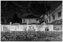 Fenced buildings with propaganda posters at night. Ho Chi Minh City, Vietnam ( black and white)