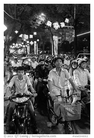 Street packed with motorbikes and bicycle riders at night. Ho Chi Minh City, Vietnam (black and white)