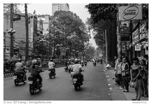 Motorbike traffic and pedestrians waiting for bus. Ho Chi Minh City, Vietnam (black and white)