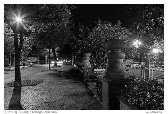 Sidewalk and park at night. Ho Chi Minh City, Vietnam (black and white)