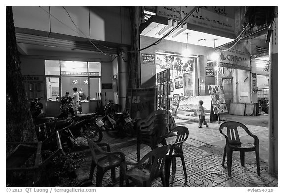 Communist party office and store selling images at night. Ho Chi Minh City, Vietnam (black and white)