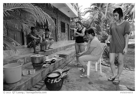 Vacationers frying fish in resort. Mui Ne, Vietnam (black and white)
