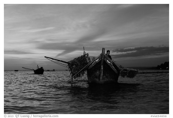 Man on fishing boat at sunset. Mui Ne, Vietnam