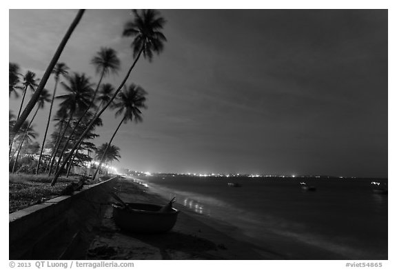 Beach, palm trees and coracle boats at night. Mui Ne, Vietnam (black and white)