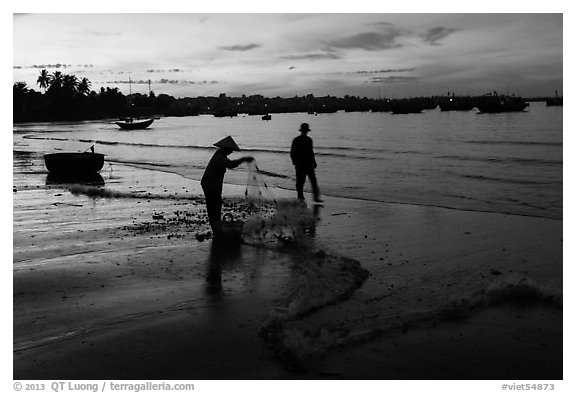 Woman collecting fishing net at dawn. Mui Ne, Vietnam (black and white)
