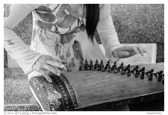 Close up of hands playing plucked zither. My Tho, Vietnam