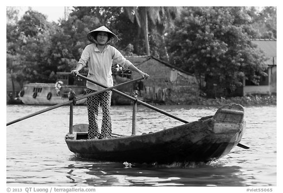 Woman using the distinctive x-shape paddle. Can Tho, Vietnam (black and white)