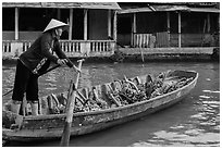 Woman paddling sampan boat loaded with bananas. Can Tho, Vietnam (black and white)