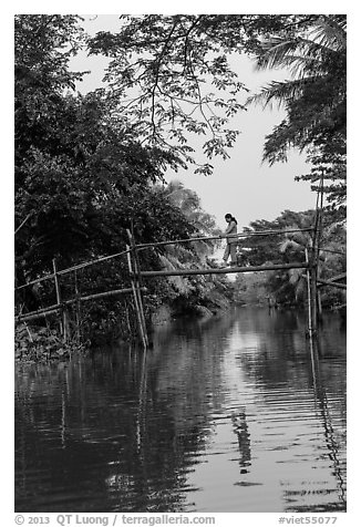 Woman walking across monkey bridge. Can Tho, Vietnam (black and white)