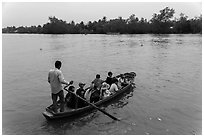 Schoolchildren crossing river on boat. Can Tho, Vietnam (black and white)