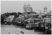 Riverside houses on stilts and Cao Dai temple. Mekong Delta, Vietnam (black and white)