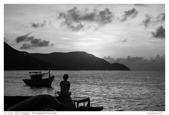 Silhouetted woman watching sunrise from Wharf 914, Con Son. Con Dao Islands, Vietnam (black and white)