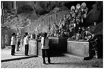 Women praying at the altar at the entrance of Tan Thanh Cave. Lang Son, Northest Vietnam ( black and white)