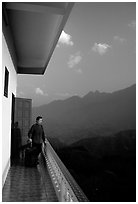 Traveler on a hotel balcony, looking at the Hoang Lien Mountains. Sapa, Vietnam (black and white)