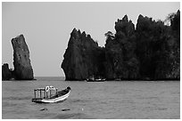 Small boats and offshore rock formations. Hong Chong Peninsula, Vietnam (black and white)