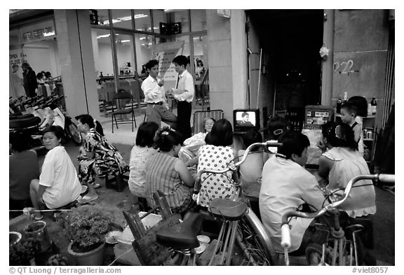 Watching TV on the street with the neighboors. Ho Chi Minh City, Vietnam (black and white)