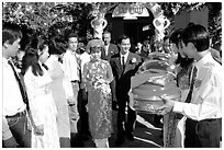 Exchange of gifts at wedding, upon exiting bride's home. The bride traditionaly wears red. Ho Chi Minh City, Vietnam (black and white)