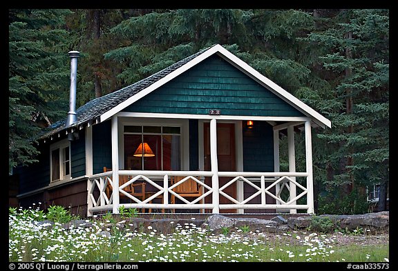 Cabin in forest with interior lights. Banff National Park, Canadian Rockies, Alberta, Canada