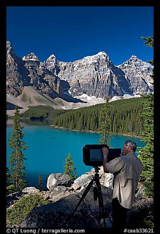 Photographer operating a 8x10 view camera at Moraine Lake. Banff National Park, Canadian Rockies, Alberta, Canada (color)