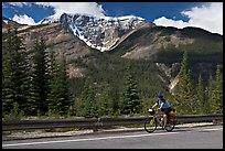 Woman cycling the Icefields Parkway. Jasper National Park, Canadian Rockies, Alberta, Canada (color)