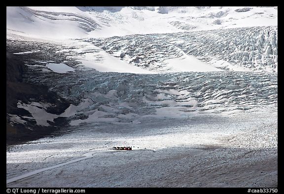 Distant view of snowcoaches parked at the base of the lower icefall on the Athabasca Glacier. Jasper National Park, Canadian Rockies, Alberta, Canada (color)