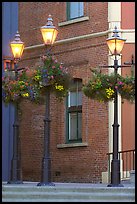 Street lamps with flower baskets and brick wall. Victoria, British Columbia, Canada (color)