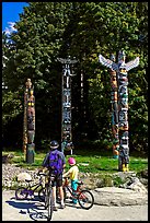 Family with bicycles looking at Totems, Stanley Park. Vancouver, British Columbia, Canada ( color)